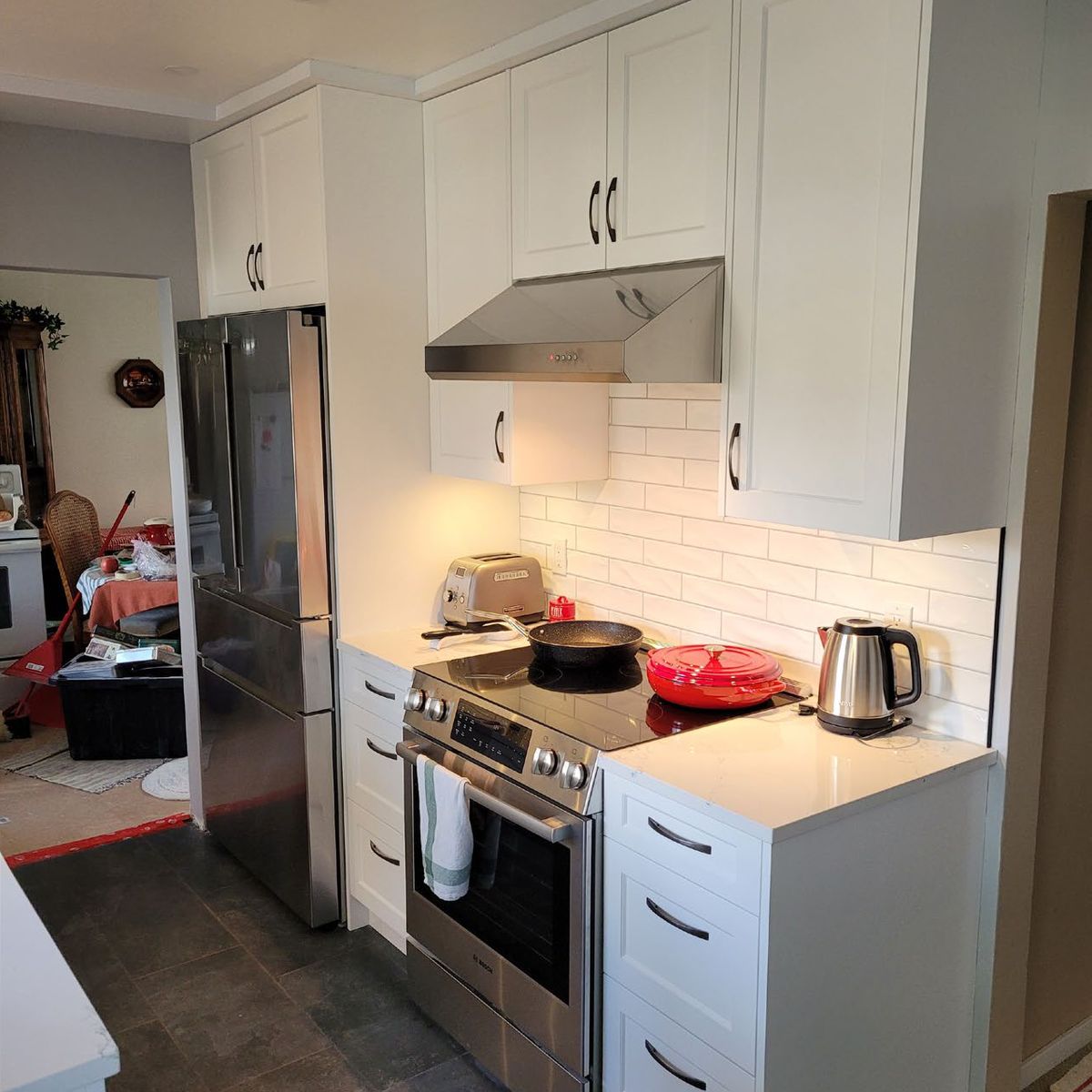 Kitchen after renovation with white shaker cabinetry and new appliances